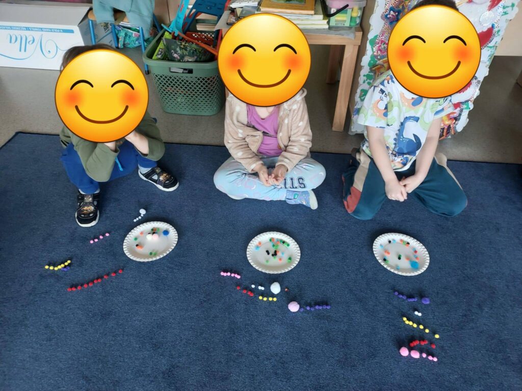 Chłopcy i dziewczynka na zdjęciu przeliczają elementy w zbiorach