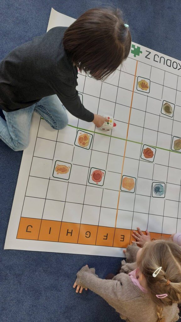 Dziewczynka programuje robota na macie