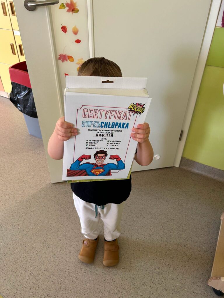 Chłopiec z certyfikatem "super chłopaka" oraz upominkiem