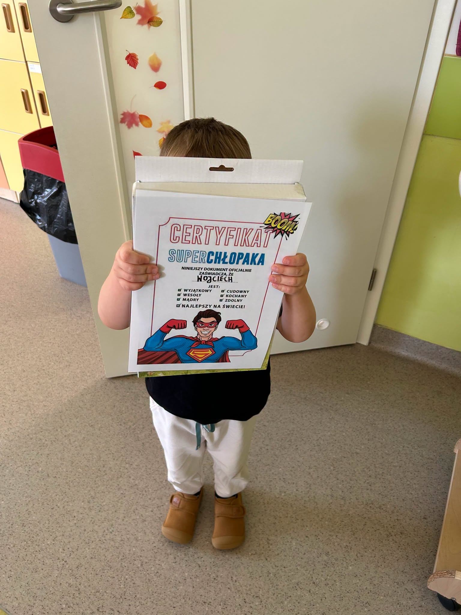 Chłopiec z certyfikatem "super chłopaka" oraz upominkiem